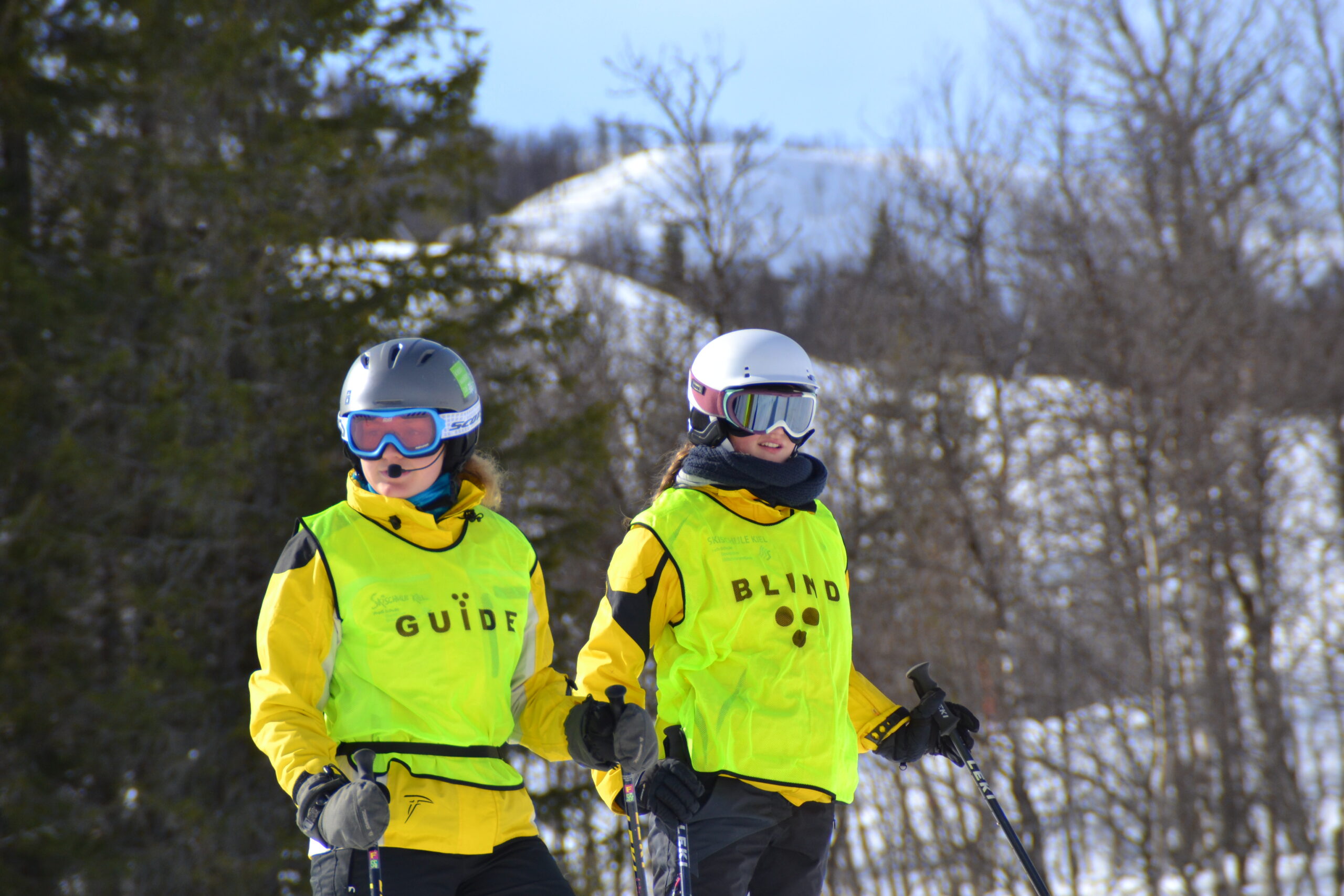 zwei Skifahrer ein Guide und einer mit der Aufschrift Blind